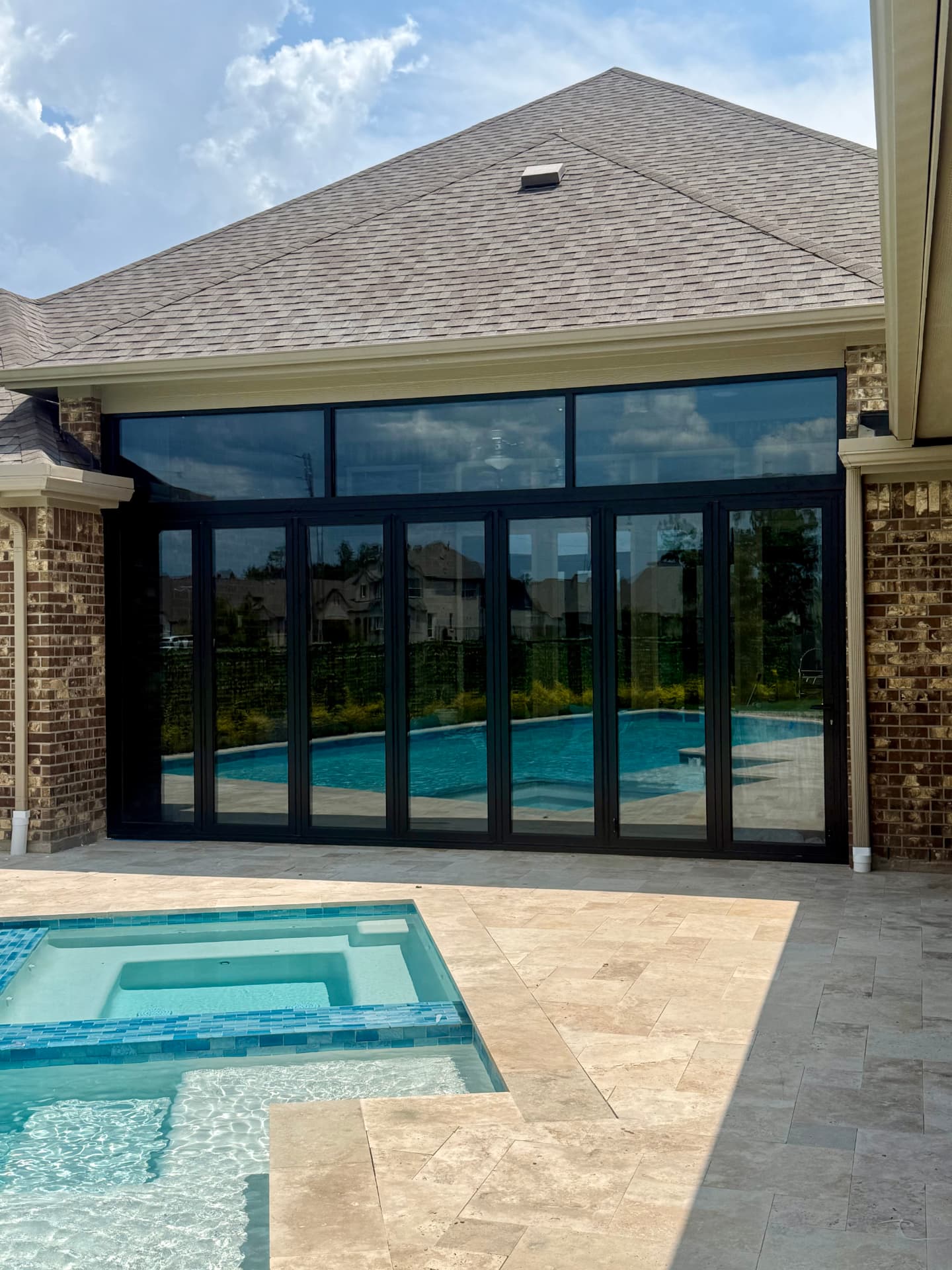 The Woodlands TX 19-foot aluminum bifold glass door with transom windows viewed from the pool patio