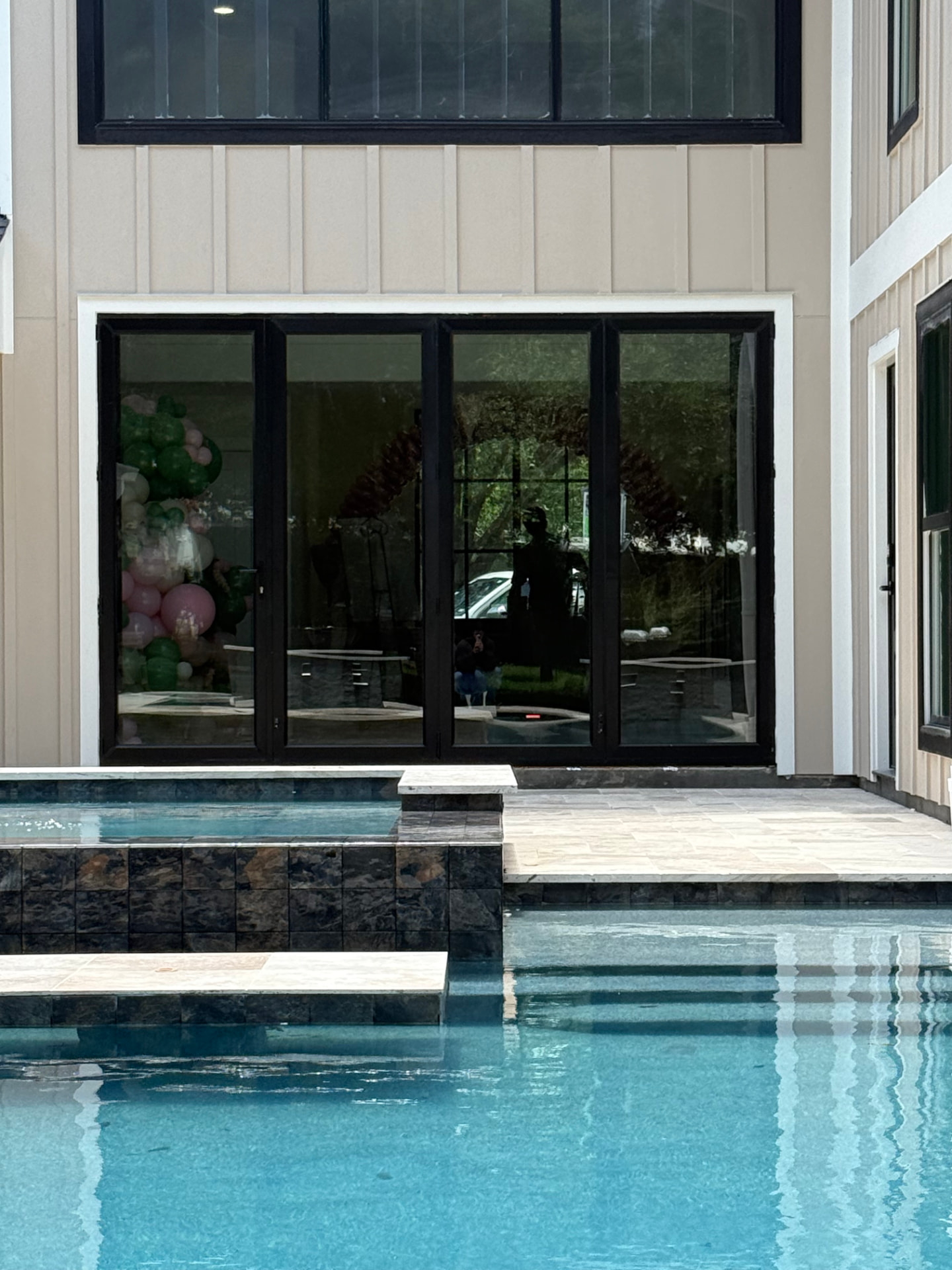 Premium aluminum bifold glass door with black frames beside a pool in Houston, TX