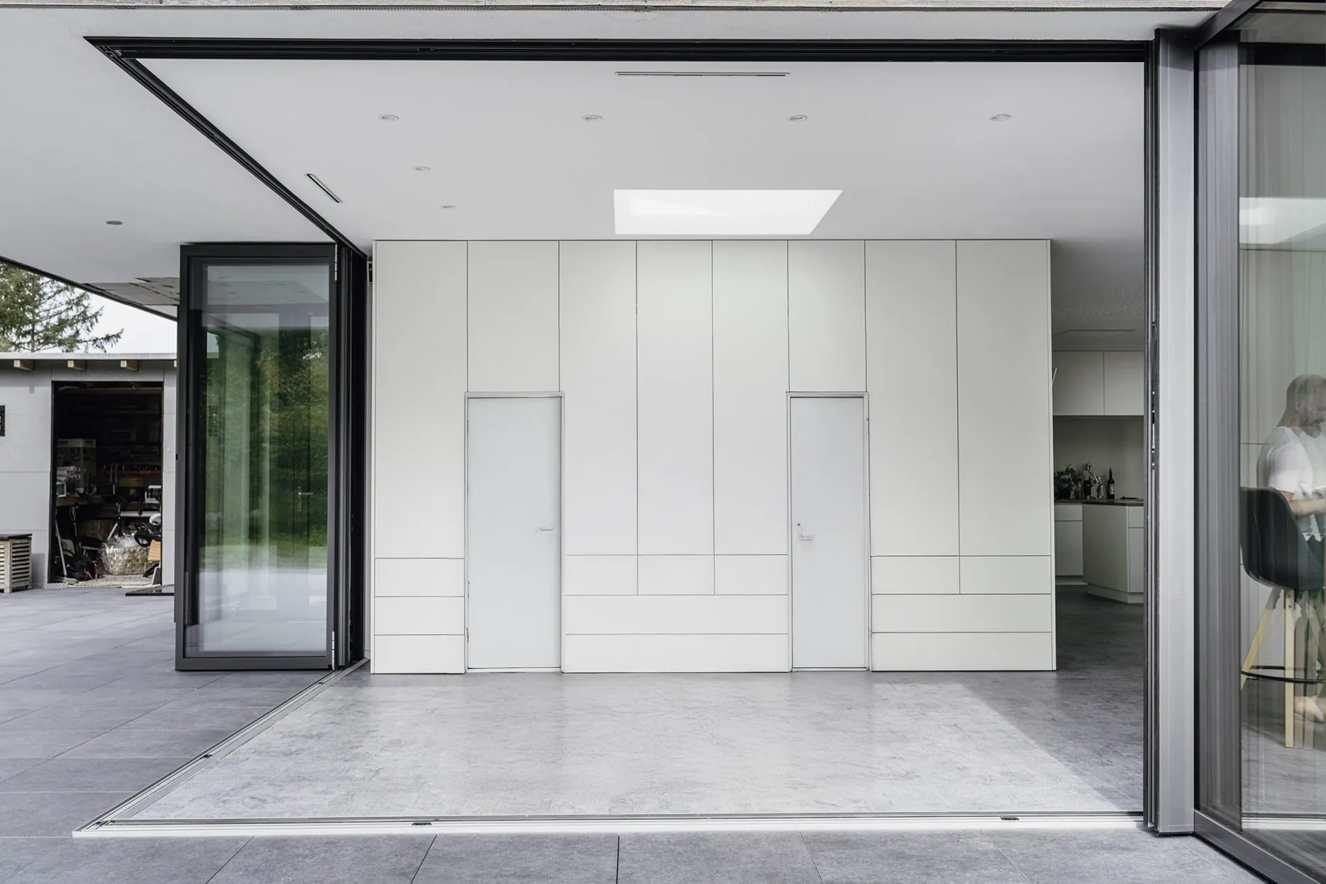 Aluminum bifold accordion folding glass doors fully opened to a Houston patio
