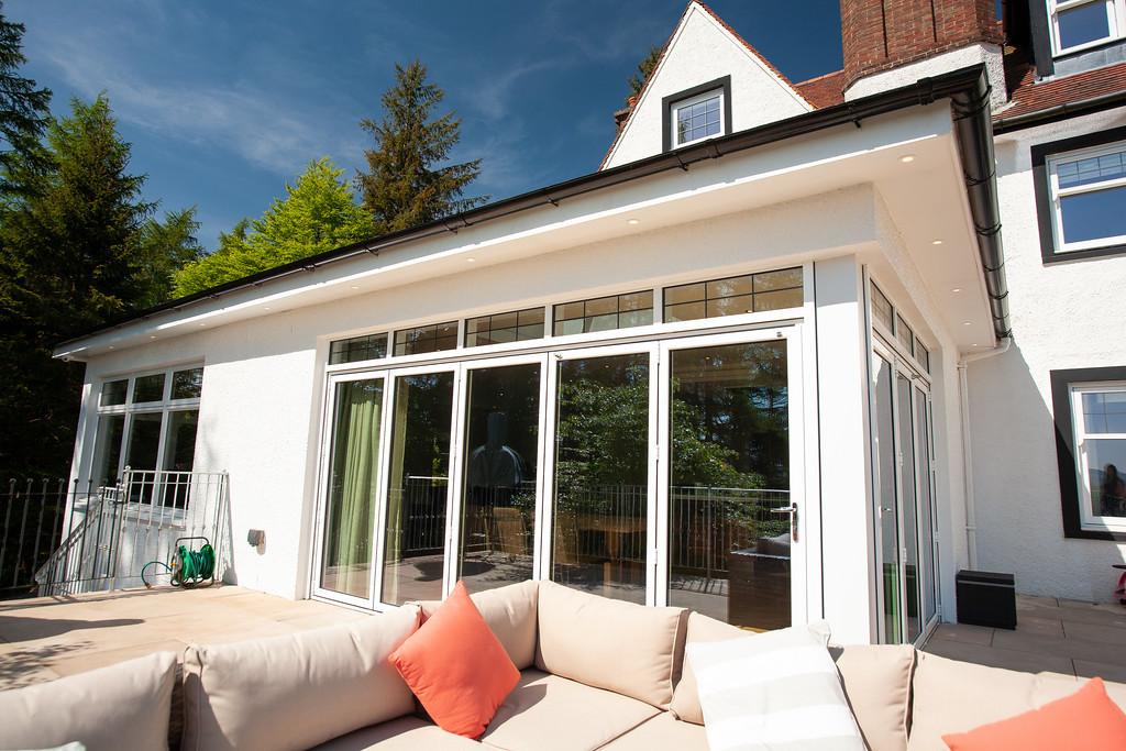 White aluminum bifold doors on modern home exterior