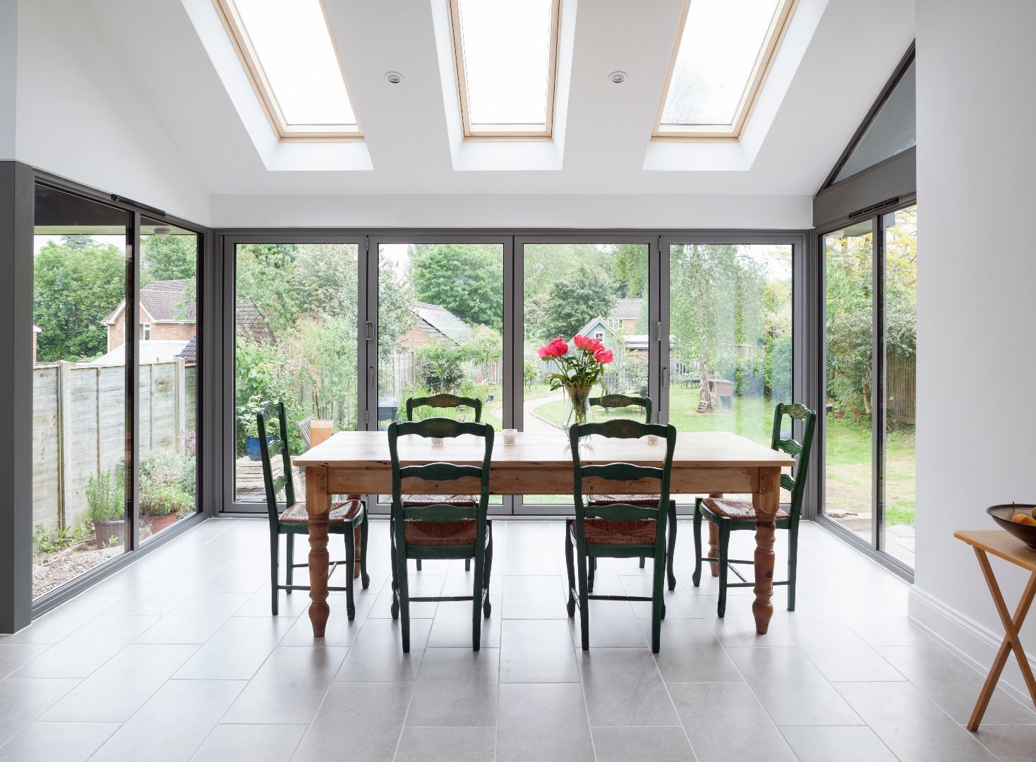 Interior view of a thermally broken aluminum folding door system opening a living room to the patio