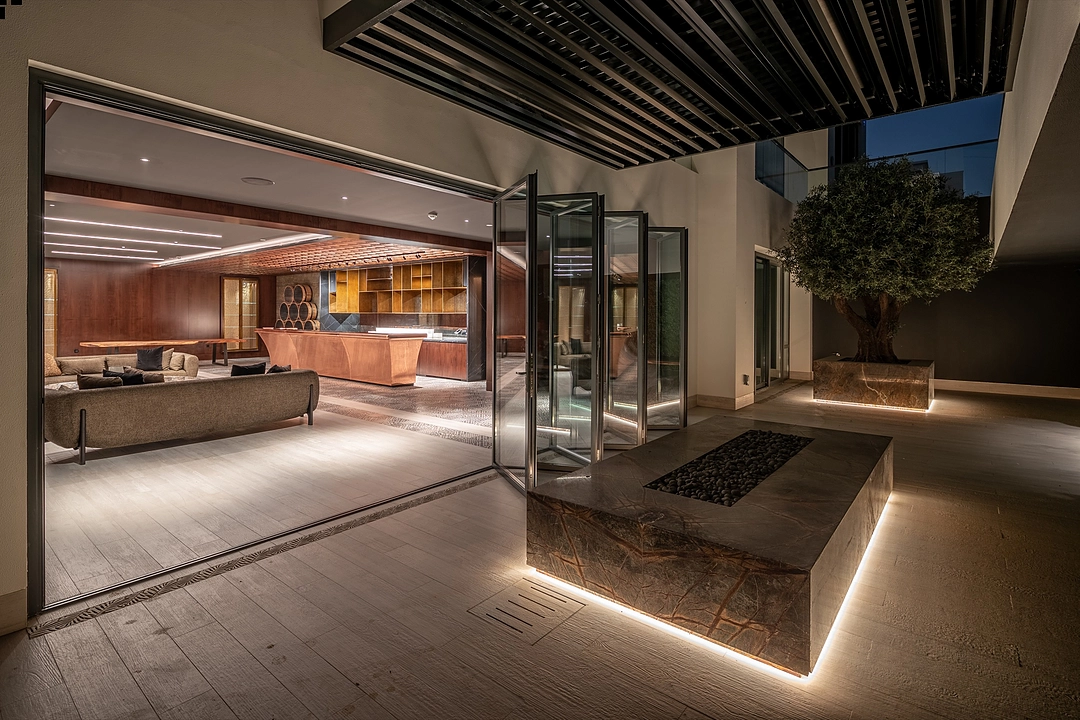 Luxury bifold doors open to courtyard — evening lighting