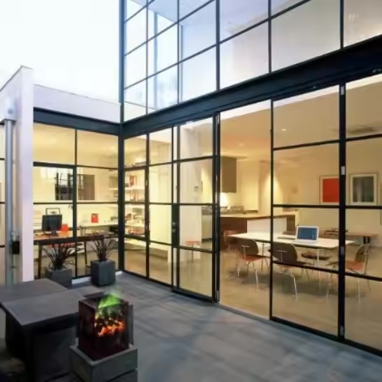 Contemporary home with floor-to-ceiling aluminum sliding doors at night